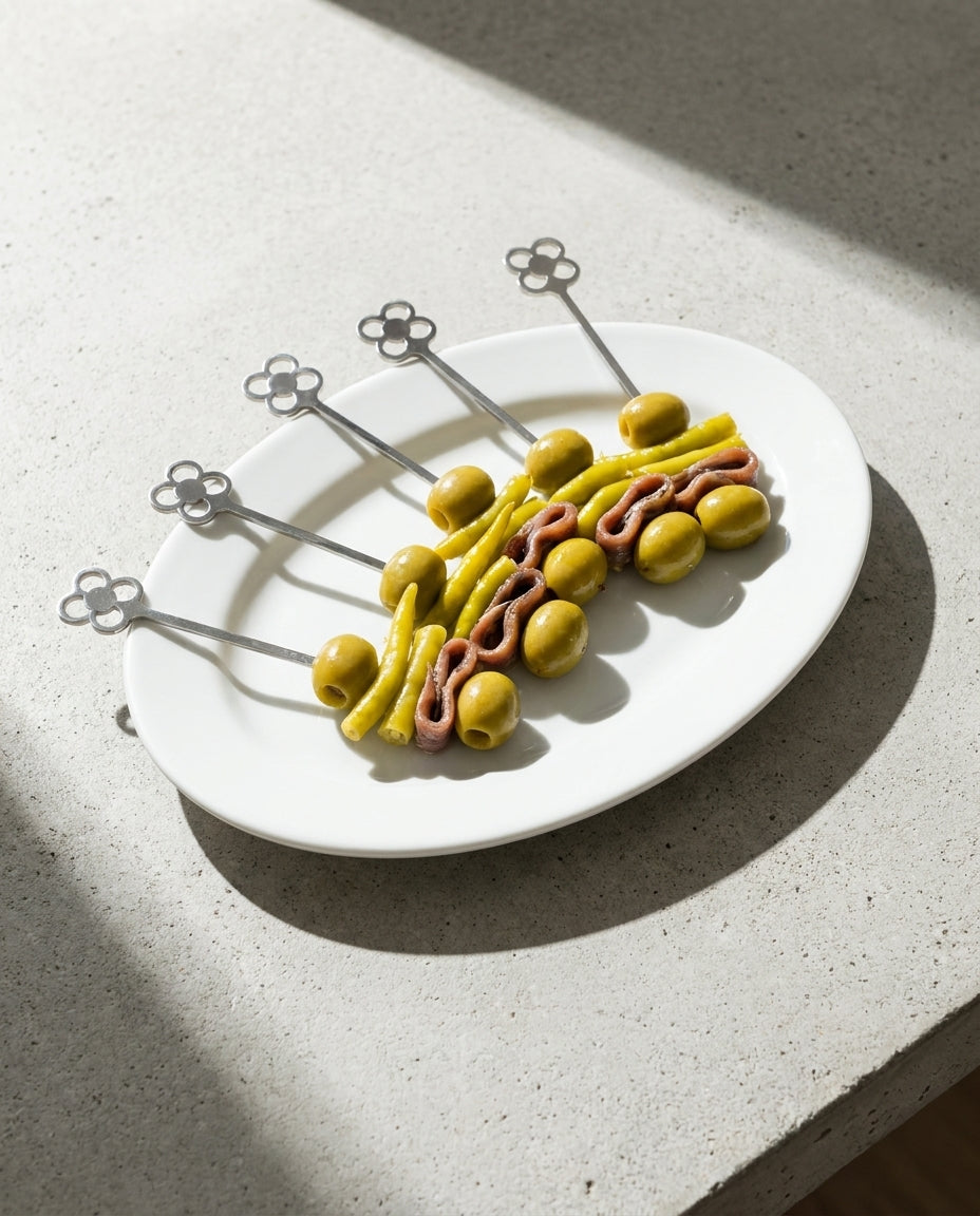 Juego de cinco brochetas de metal del panot de Barcelona presentando gildas clásicas en un plato